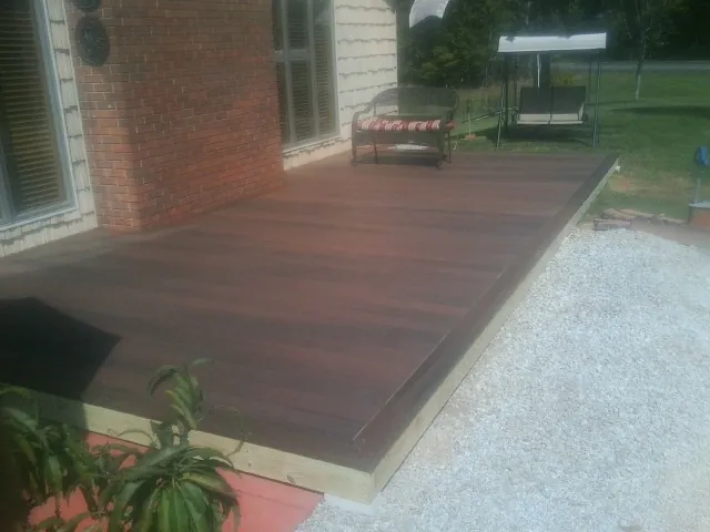 Freshly stained wood deck built against a brick home in Templeton