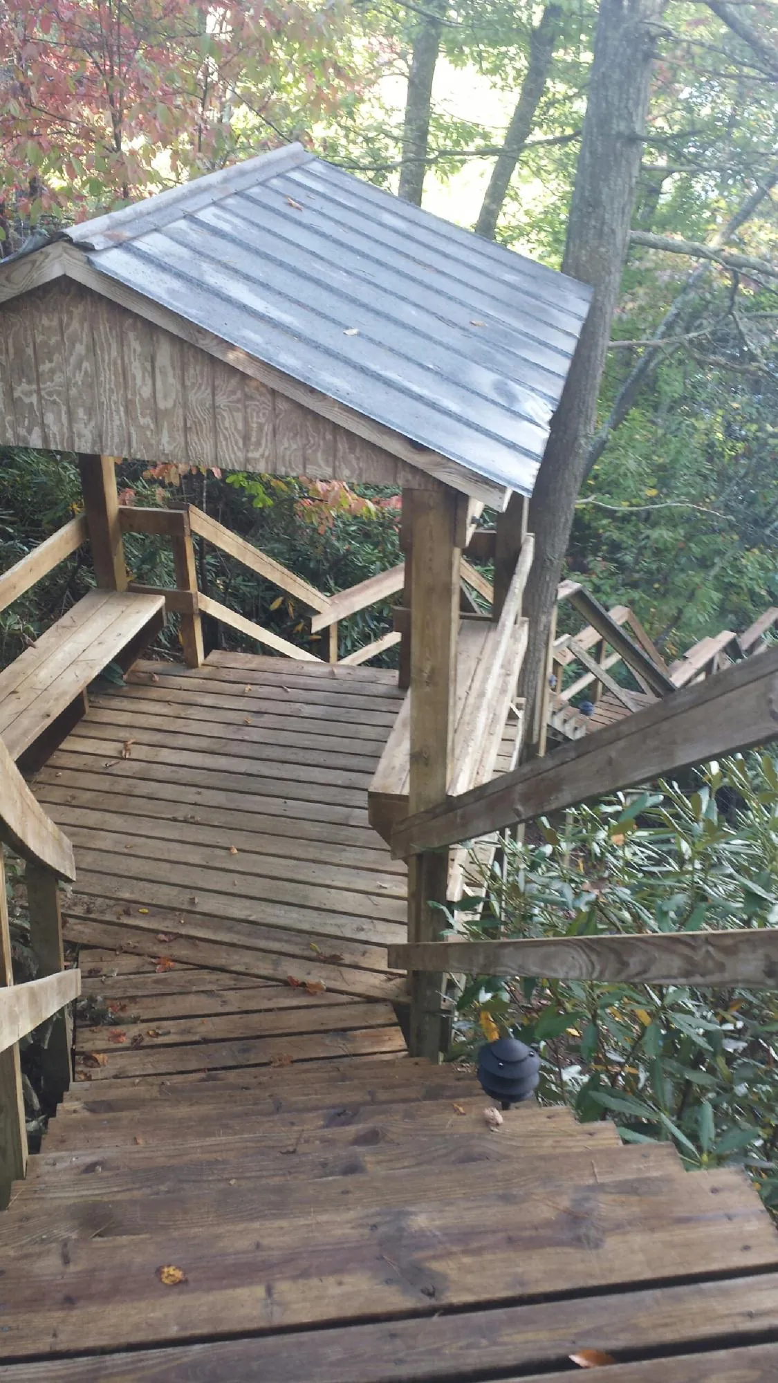 Metal roofed shelter over wooden steps on a wooded walkway — Skylight Repair & Installation work by our crew in Templeton
